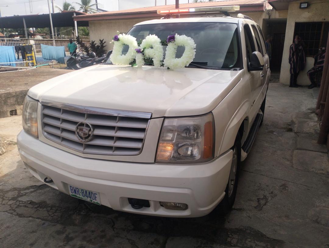 Funeral hearse decorated with a floral 'DAD' tribute on the bonnet